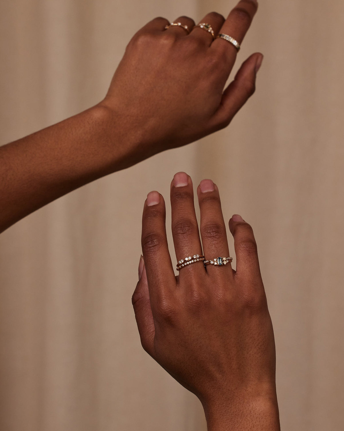 [lifestyle]Two hands with multiple rings on a beige background