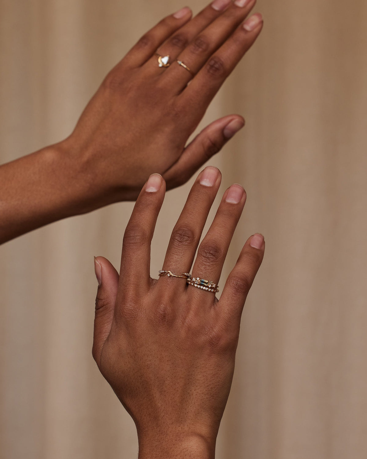 [lifestyle]Two hands with gold rings on a beige background