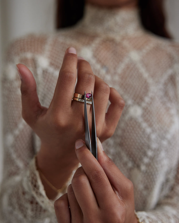 [lifestyle]Close-up of a hand with a ring holding tweezers, wearing a patterned garment.