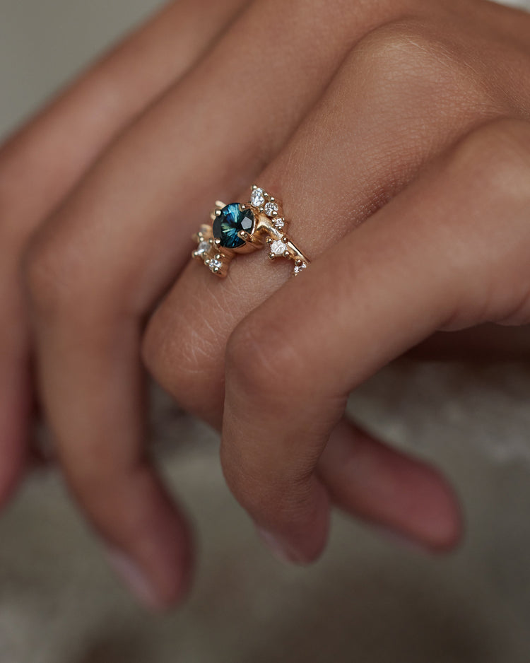 [lifestyle]Gold ring with a blue gemstone on a hand